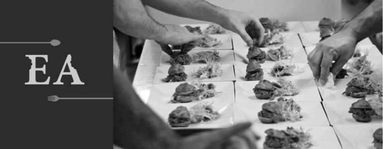 Hands preparing plated meals
