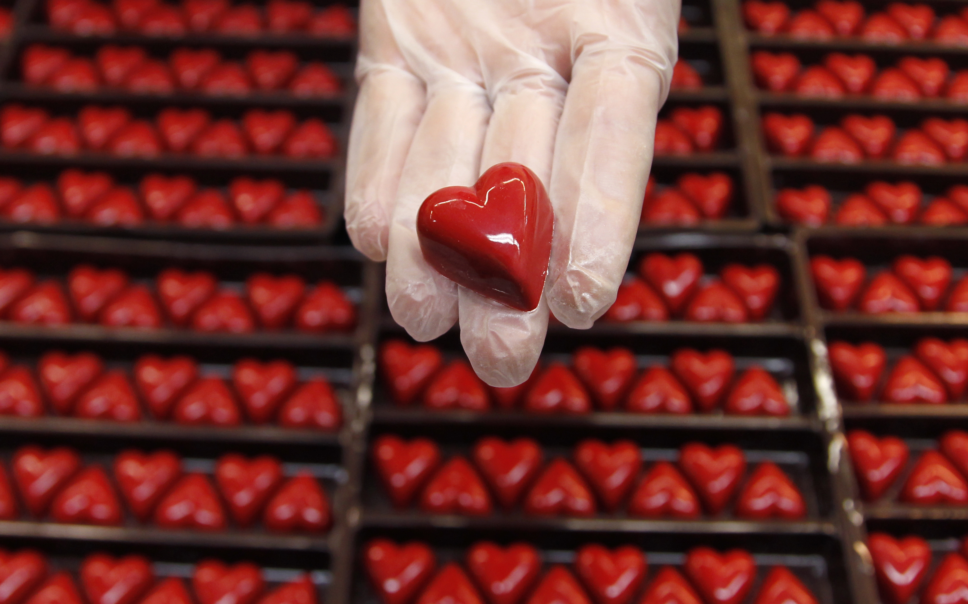 A worker displays a heart-shaped praline for Valentine's Day at a Wittamer chocolate boutique in Brussels February 14, 2012. REUTERS/Francois Lenoir (BELGIUM - Tags: FOOD SOCIETY) - RTR2XTWN