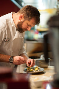the chef prepares a dish at Asheville's Lobster Trap restaurant